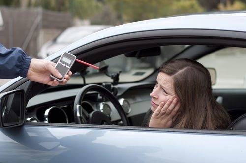 automovilista siendo solicitado a someterse a una prueba de alcoholemia portátil