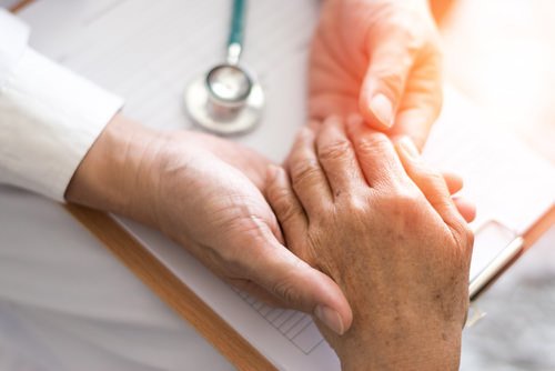 patient holding physician's hand