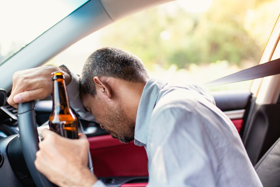 Conducción borracha con botella de cerveza