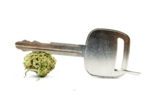 Car key and marijuana against white background