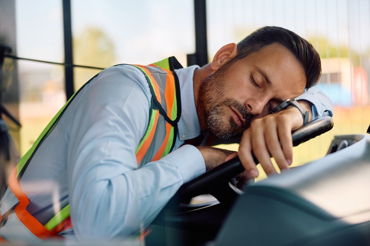 Conductor de autobús fatigado durmiendo en el volante