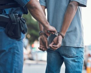 Close-up of a policeman handcuffing a man following a warrantless arrest